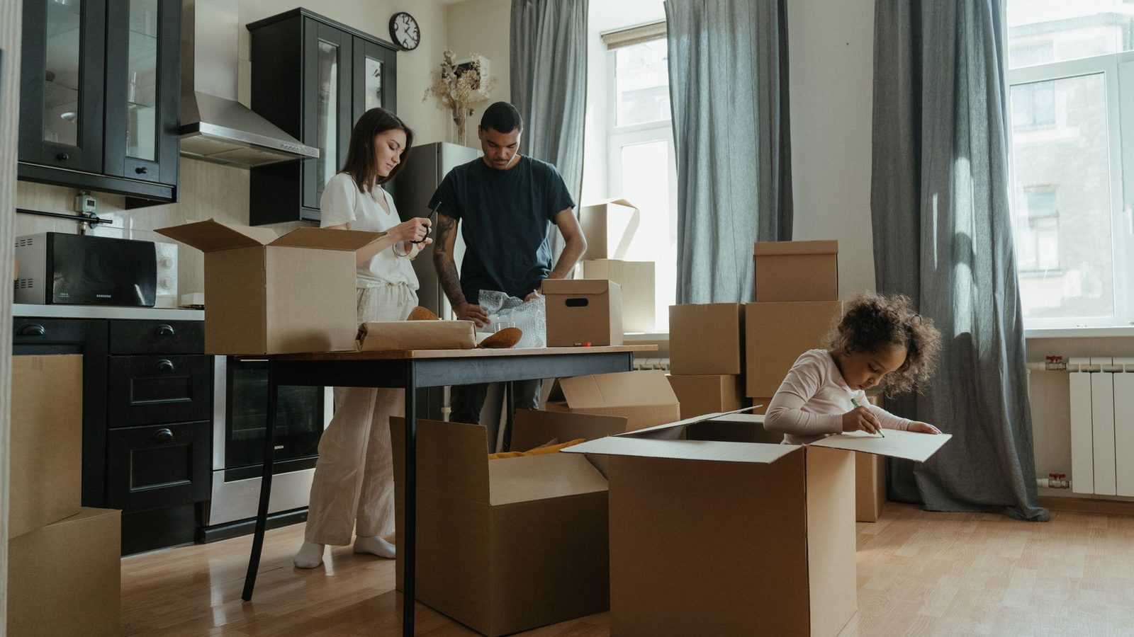 Famille déballant ses cartons dans la cuisine de son nouveau logement à Antibes